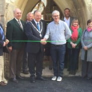 People cutting a ribbon to open building.