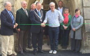 People cutting a ribbon to open building.