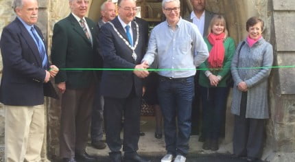 People cutting a ribbon to open building.