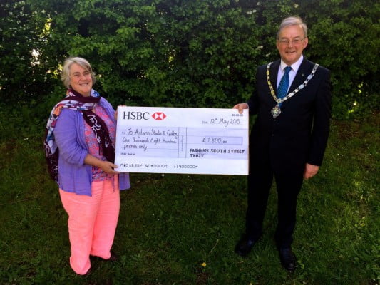 Mayor hands large cheque to lady.