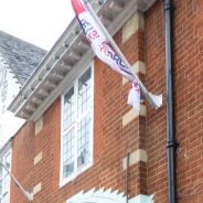 two flags outside of a redbrick building.