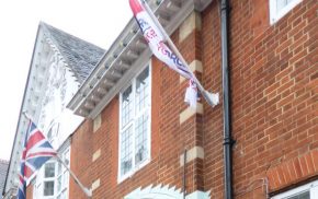 two flags outside of a redbrick building.