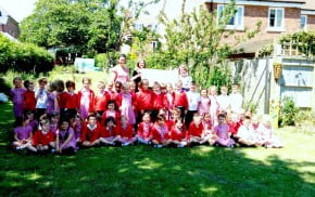 Large group of children and the Mayor in garden.