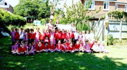 Large group of children and the Mayor in garden.