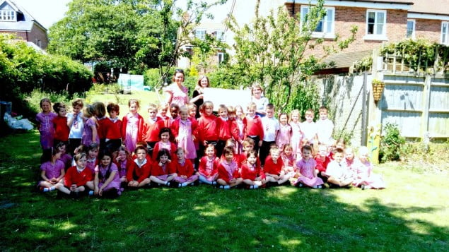 Large group of children and the Mayor in garden.