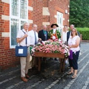 People standing next to hop cart filled with flowers