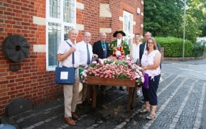 People standing next to hop cart filled with flowers