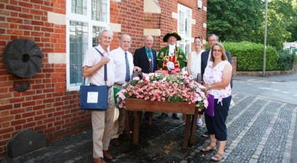 People standing next to hop cart filled with flowers