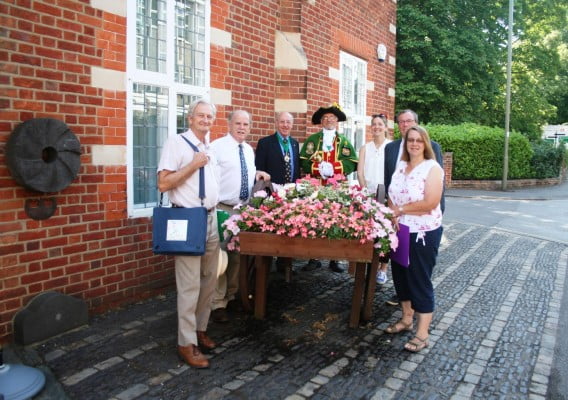 People standing next to hop cart filled with flowers