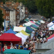 Brightly coloured marquees in street and crowds of people