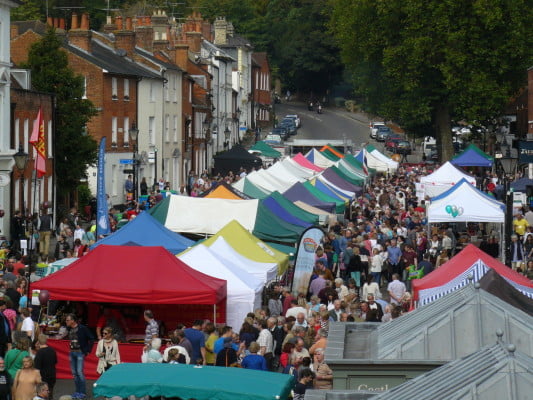 Brightly coloured marquees in street and crowds of people
