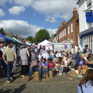 crowds of people eating, colourful gazebos on the left.