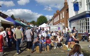 crowds of people eating, colourful gazebos on the left.