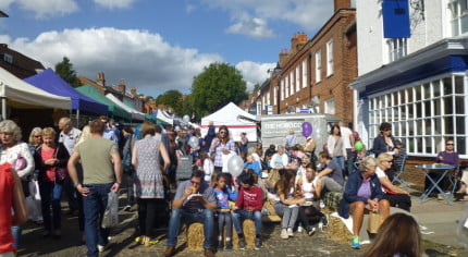 crowds of people eating, colourful gazebos on the left.