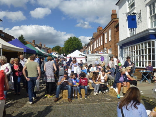 crowds of people eating, colourful gazebos on the left.