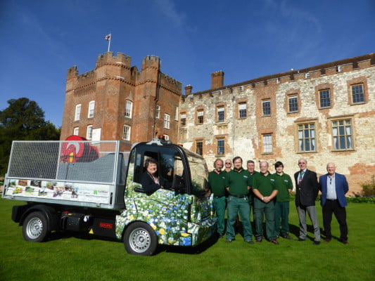 group of males on the right, female in a floral van, stone castle in background.