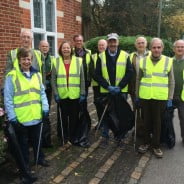 Councillors in high visibility jackets holding litter pickers and sacks of rubbish.