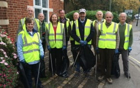 Councillors in high visibility jackets holding litter pickers and sacks of rubbish.