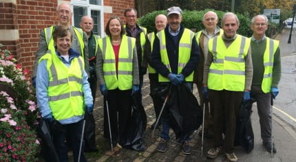 Councillors in high visibility jackets holding litter pickers and sacks of rubbish.