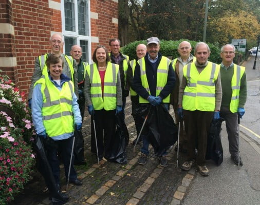 Councillors in high visibility jackets holding litter pickers and sacks of rubbish.