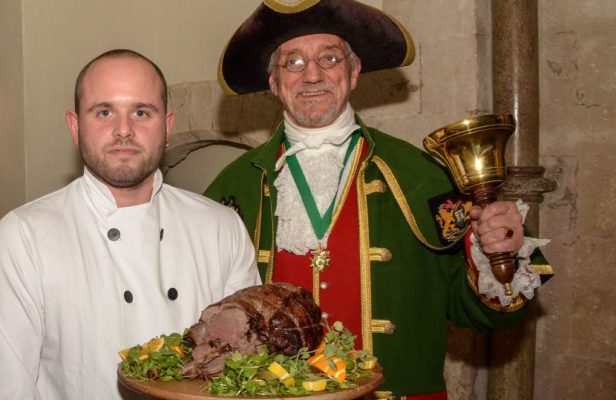 Piper, chef holding venison on a platter and the Town Crier.