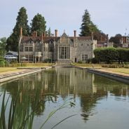 Exterior of large grand house with ornamental pond in foreground