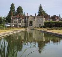 Exterior of large grand house with ornamental pond in foreground