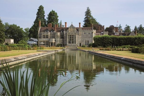 Exterior of large grand house with ornamental pond in foreground