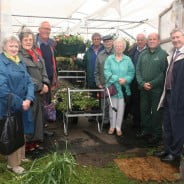 Three females and six males in entrance to greenhouse