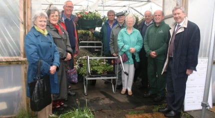 Three females and six males in entrance to greenhouse