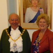 Male and female stood in front photo of the Queen