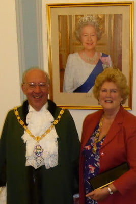 Male and female stood in front photo of the Queen