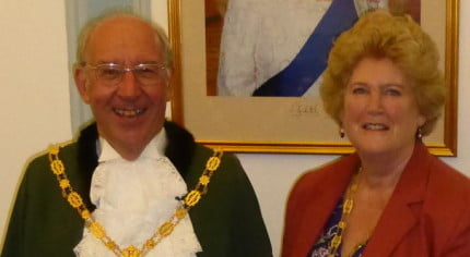 Male and female stood in front photo of the Queen