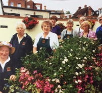 Group of females standing behind a display of plants