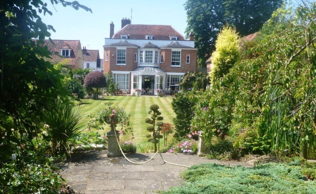 View of period house with beautiful garden in front