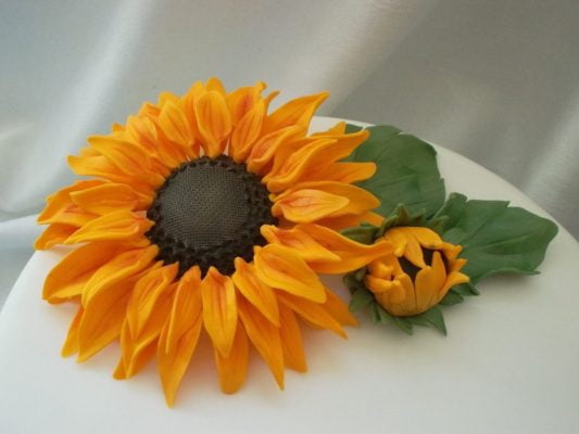 Yellow sugar paste sunflower on white cake