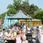 Crowds watching a band perform in the park