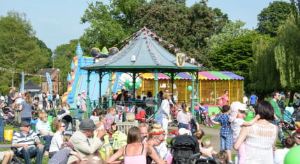 Crowds watching a band perform in the park