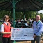 A female and male holding a large cheque for £1000.