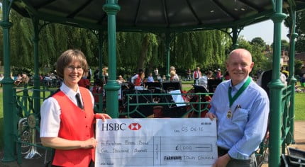 A female and male holding a large cheque for £1000.