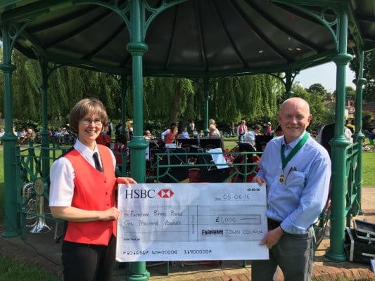 A female and male holding a large cheque for £1000.