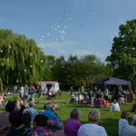 90 balloons released in park with groups of people watching