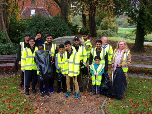 Group of young people with litter pickers and black sacks.