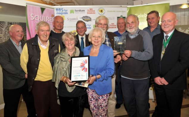 Group of people with certificate and trophy.