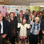 Group of people holding up grey gloves.