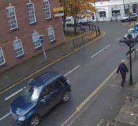 Looking down at a street with car parssing by