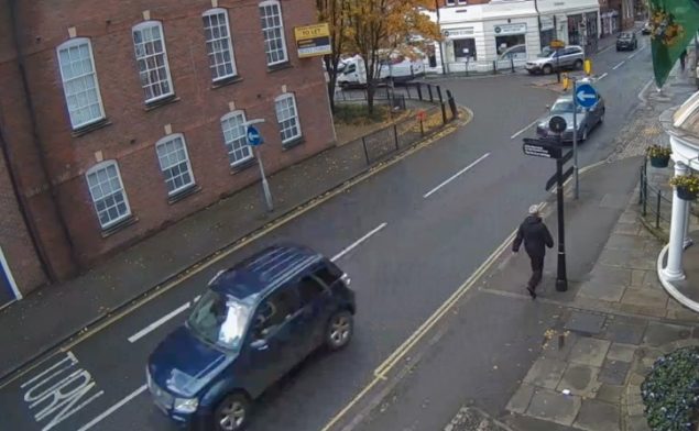 Looking down at a street with car parssing by