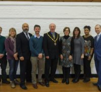 Group of people standing in a row with the Mayor in the middle.