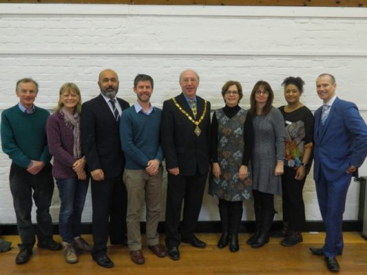 Group of people standing in a row with the Mayor in the middle.