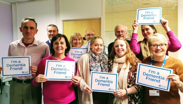 Group of people holding up signs saying "I'm a dementia friend."